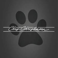 The image features a black paw print on a dark grey background with the nameChris Christensen" written in elegant cursive script across the center. This likely represents the Chris Christensen brand, known for high-quality pet grooming products.