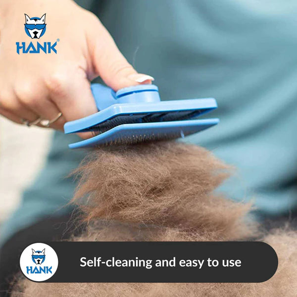 Person using a blue Self-Cleaning Slicker Brush for Pets – Grooming Tool for Cats & Dogs with collected fur, Hank brand visible