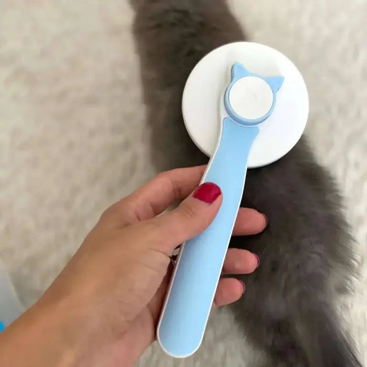 Pet Hair Removal Brush with blue handle and cat-ear design, effortlessly removing fur from a fluffy pet. Ideal grooming tool for dogs and cats.