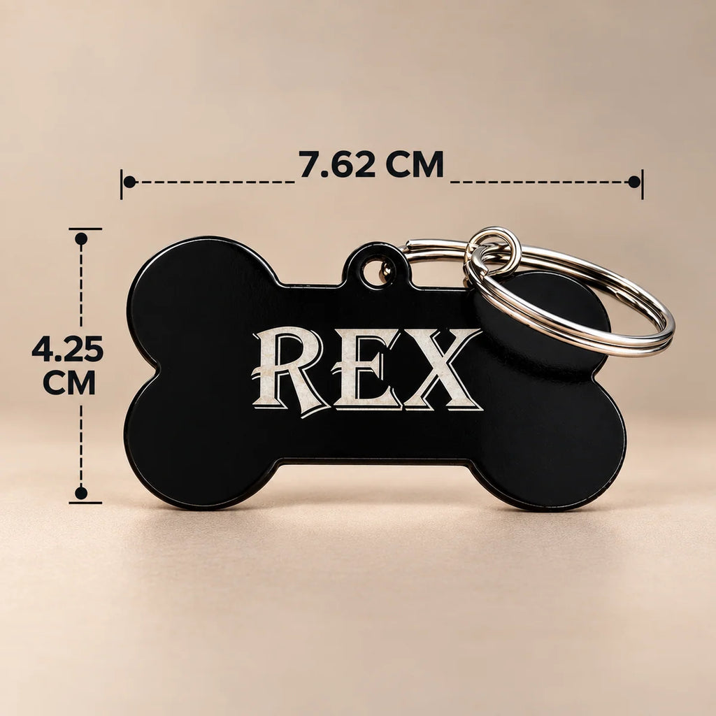 Black bone-shaped dog name tag engraved with REX, with dimensions marked 7.62 cm wide and 4.25 cm high