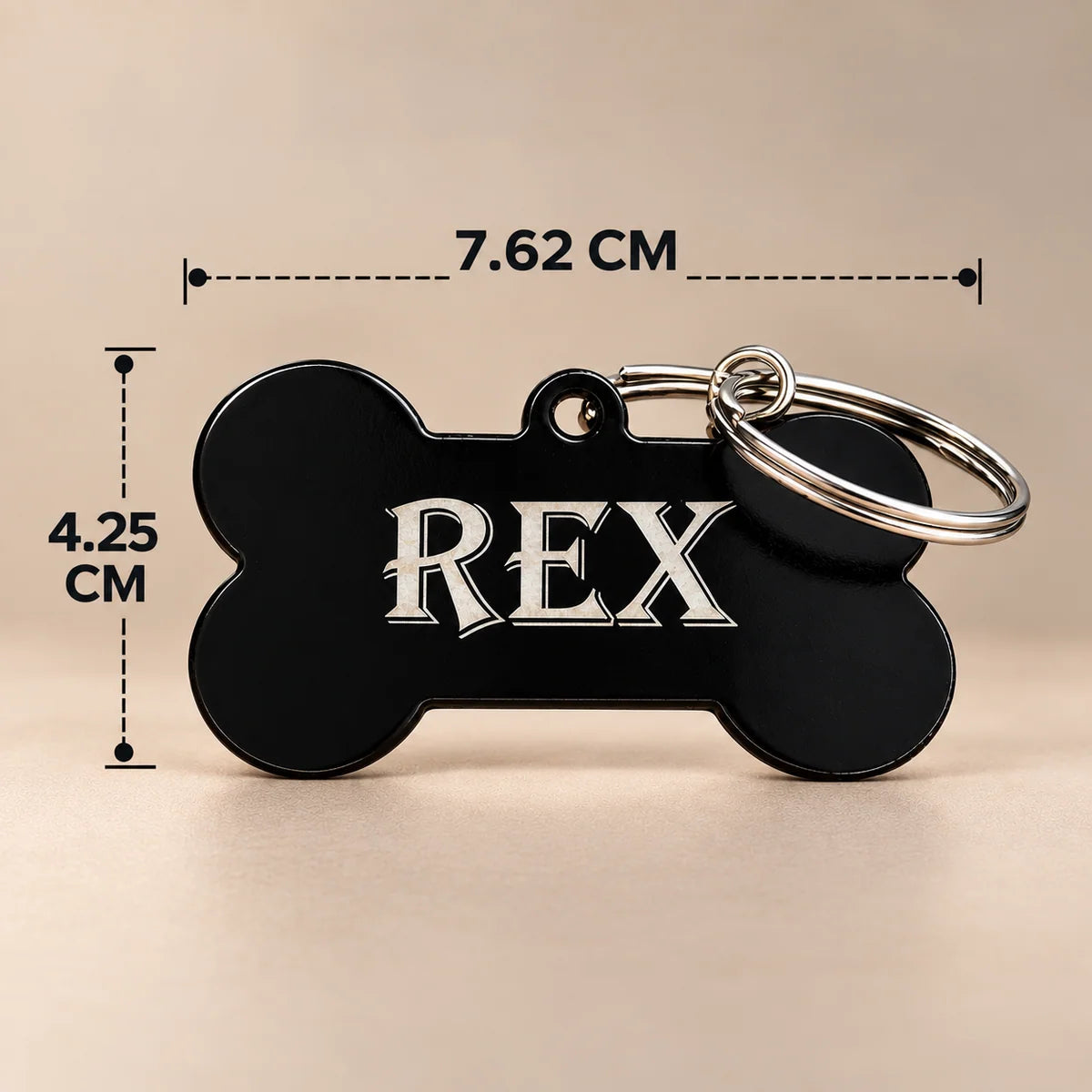 Black bone-shaped dog name tag engraved with REX, with dimensions marked 7.62 cm wide and 4.25 cm high